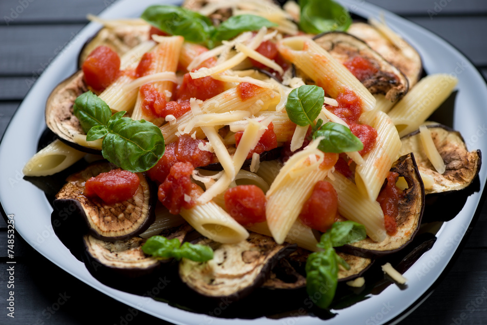 Black glass plate with pasta alla Norma, close-up, studio shot Black glass plate with pasta alla Norma, close-up, studio shot