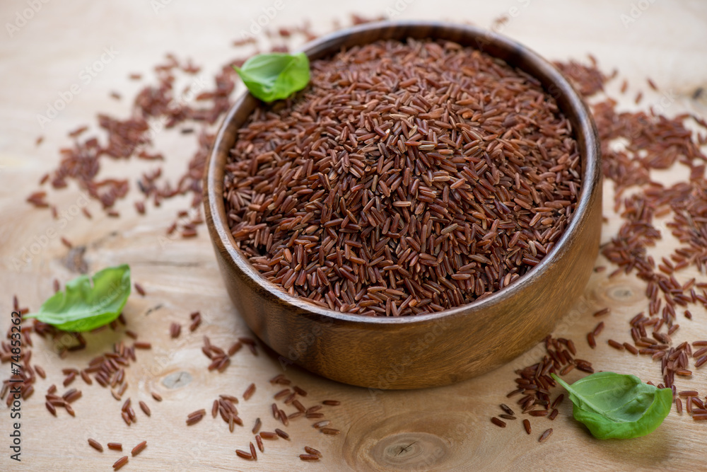 Wooden bowl with red kernel rice, close-up, studio shot Wooden bowl with red kernel rice, close-up, studio shot