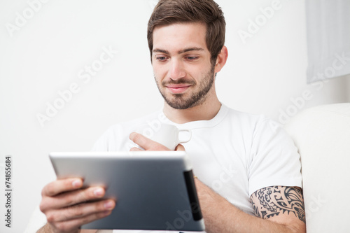Man using tablet pc during breakfast