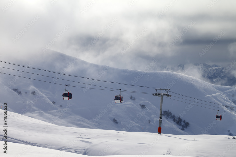 Gondola lifts and off-piste slope in mist