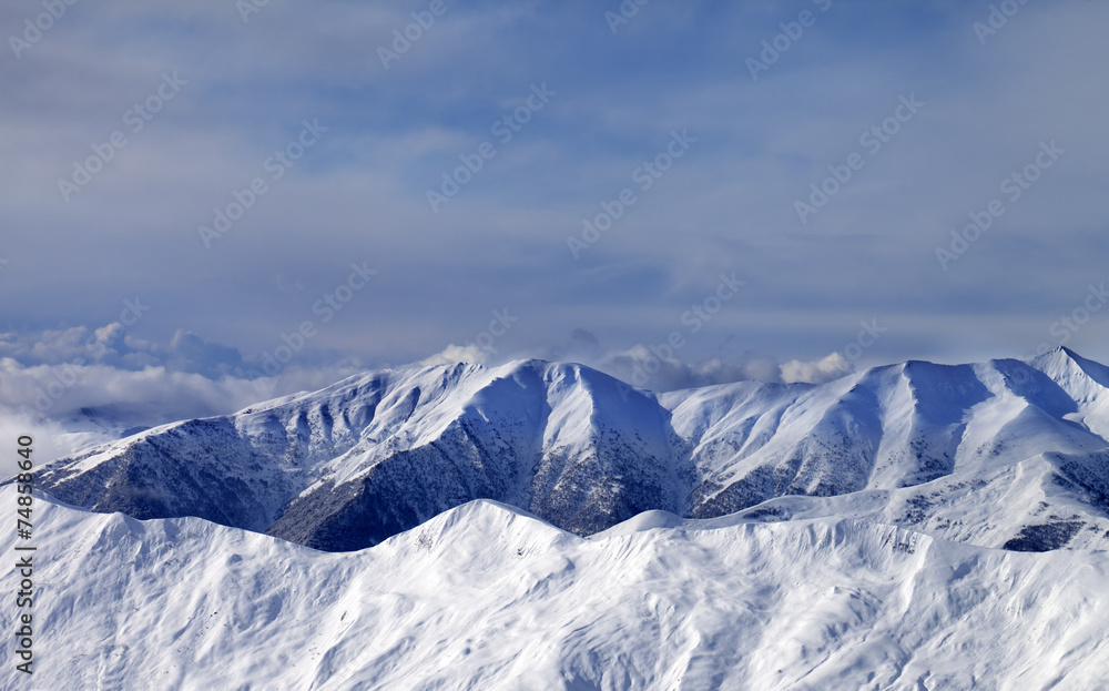 Winter mountains in clouds at windy day