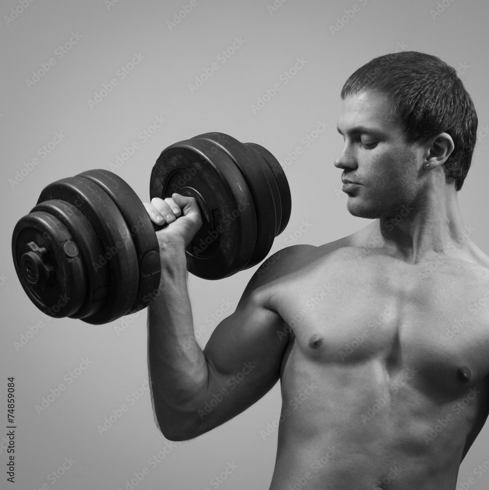 Handsome muscular male model with dumbbell. Black and white. Handsome muscular male model with dumbbell. Black and white.