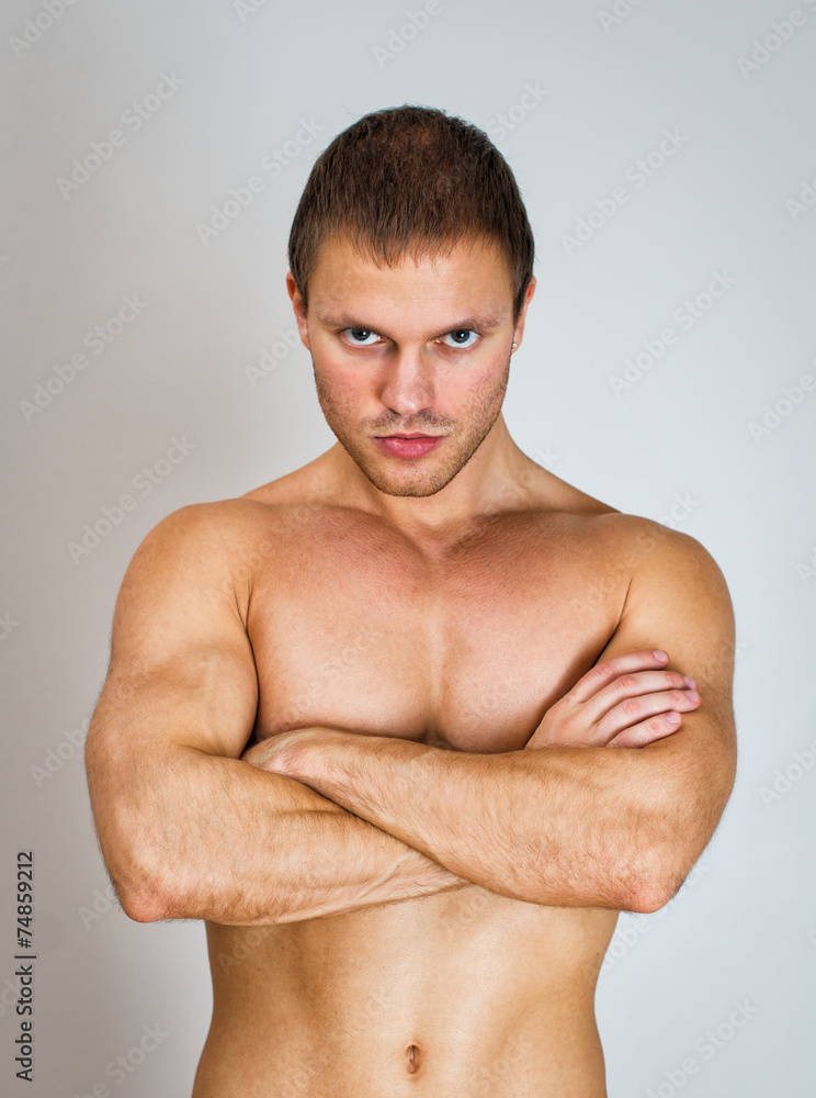 Muscular male model with arms folded.