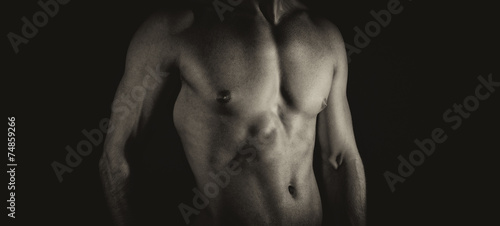 Unrecognizable muscular male body. Black and white.
