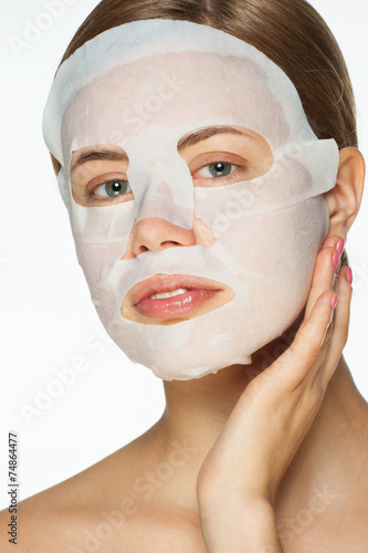 Woman applying facial mask