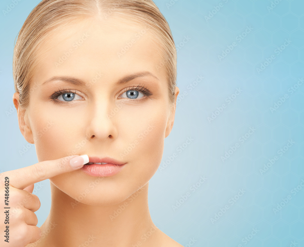 beautiful young woman pointing finger to her lips beautiful young woman pointing finger to her lips
