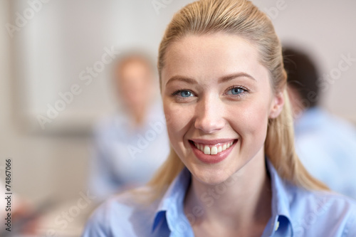 group of smiling businesspeople meeting in office