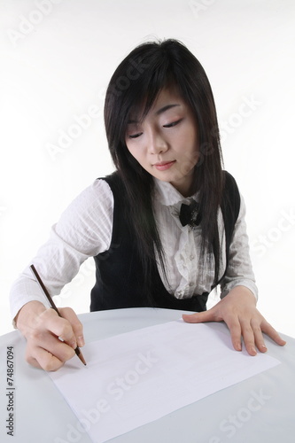 테이블에 앉아서 쓰고 있는 비즈니스 여성