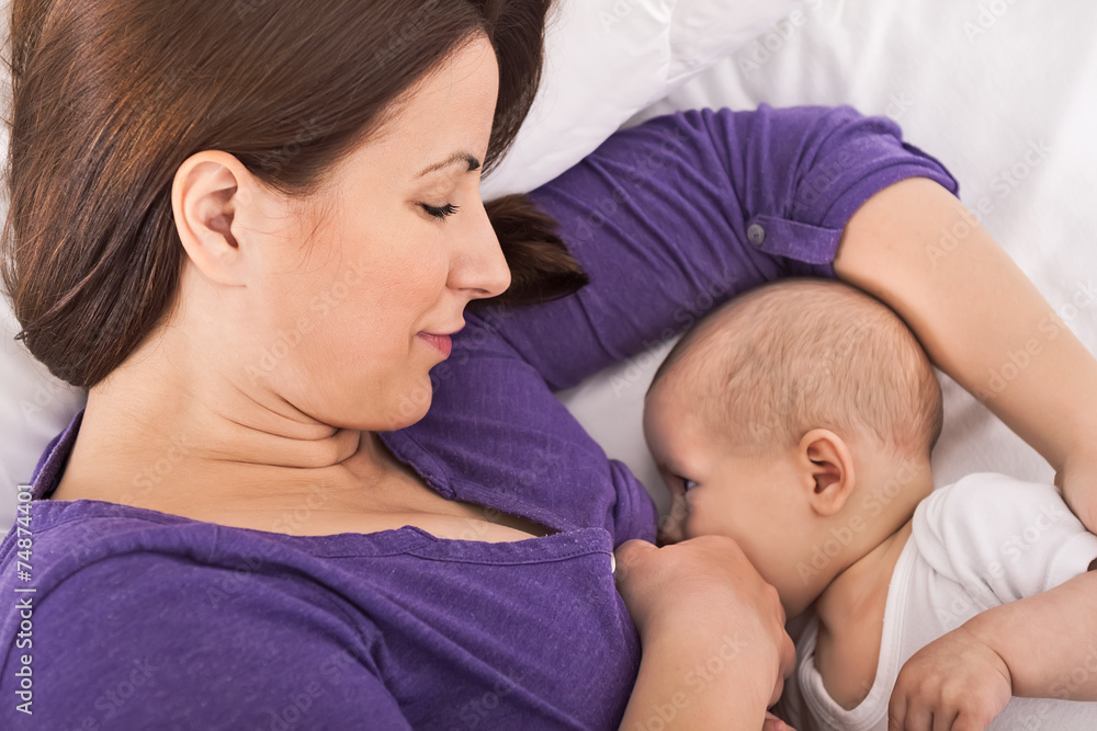 Smiling happy mother breastfeeding her baby infant Smiling happy mother breastfeeding her baby infant