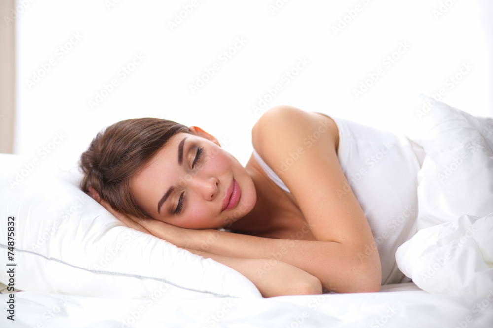 Fototapeta Piękna dziewczyna śpi w sypialni, leżąc na łóżku