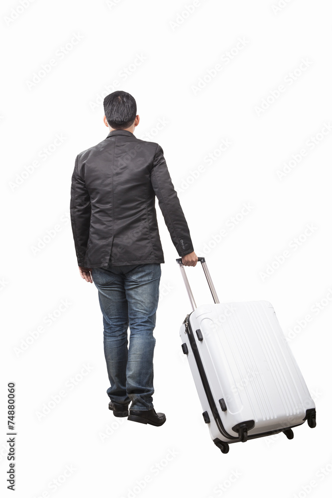 rear view of young man and pulling belonging luggage walking to rear view of young man and pulling belonging luggage walking to