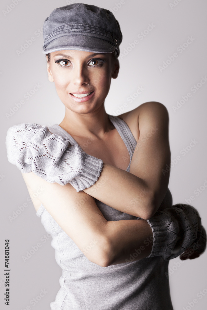 Beautiful woman with cap and gloves, on gray background - obrazy, fototapety, plakaty 