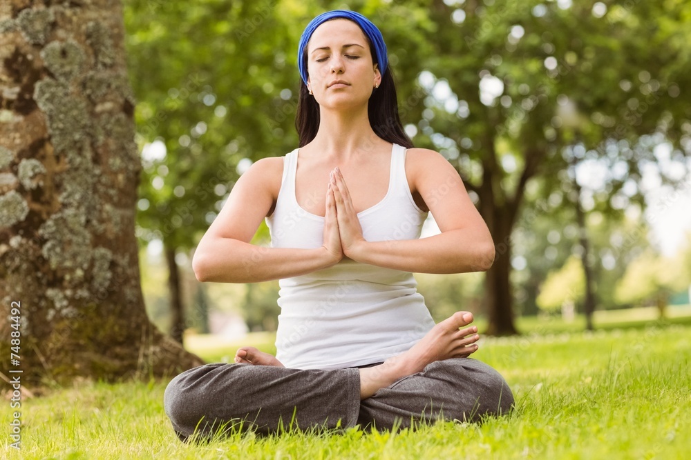 Brunette sitting in lotus pose with hands together Brunette sitting in lotus pose with hands together