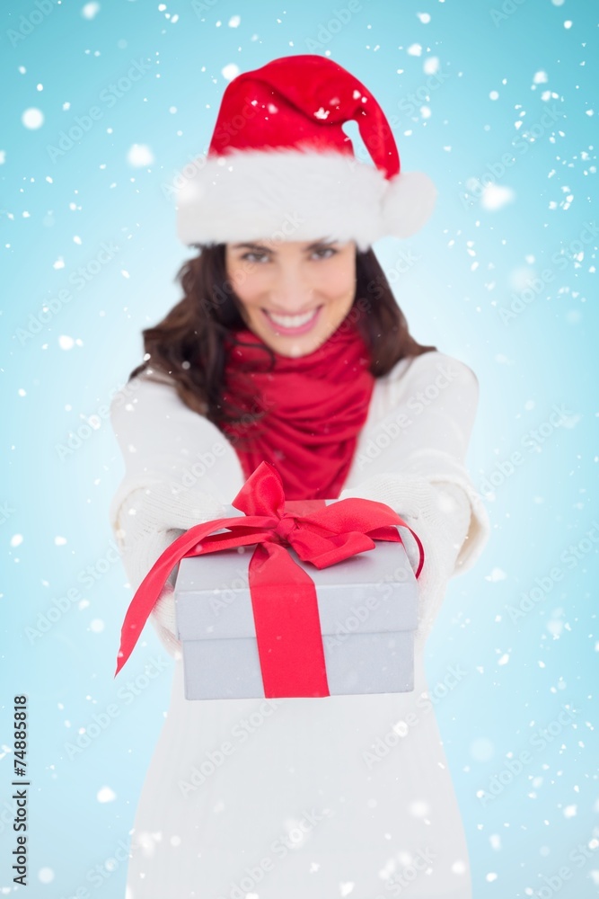 Composite image of festive brunette in santa hat giving gift Composite image of festive brunette in santa hat giving gift