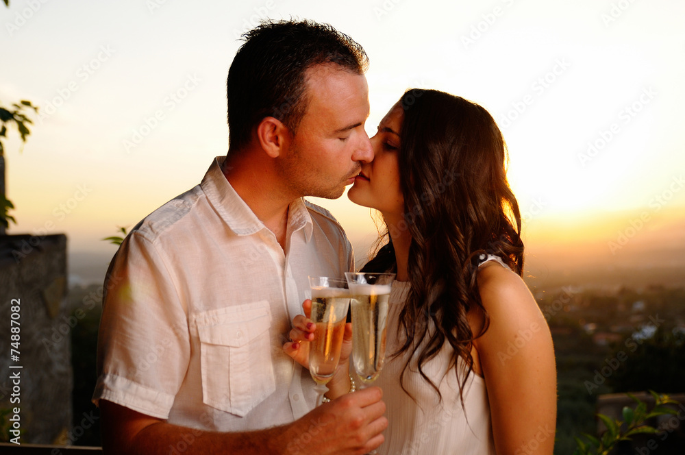 Obraz premium Toast young couple kissing at sunset