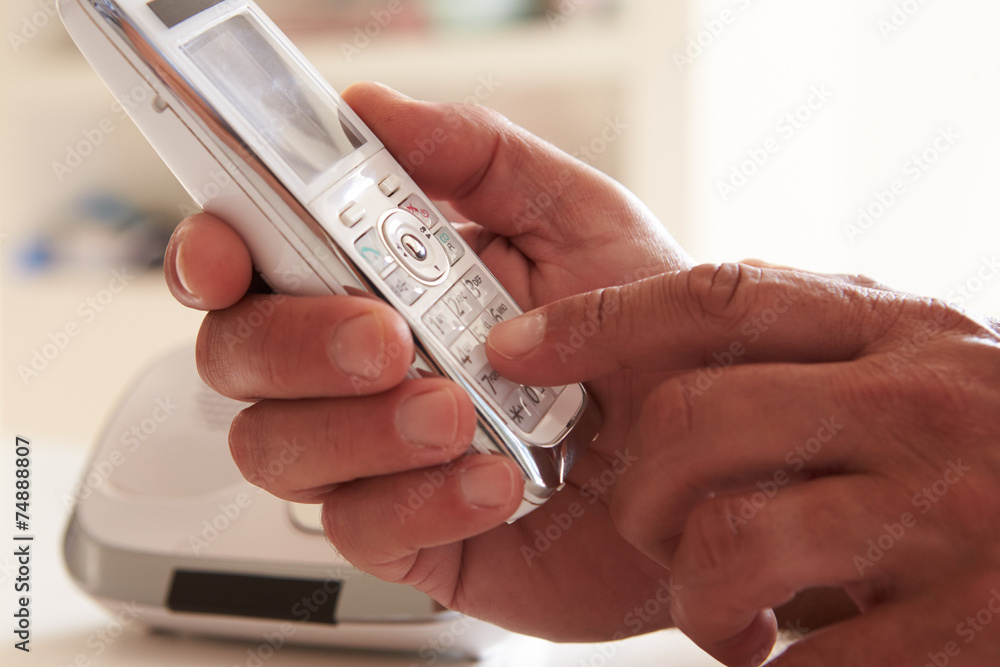 Close Up Of Man Picking Up Telephone Handset And Dialing - obrazy, fototapety, plakaty 