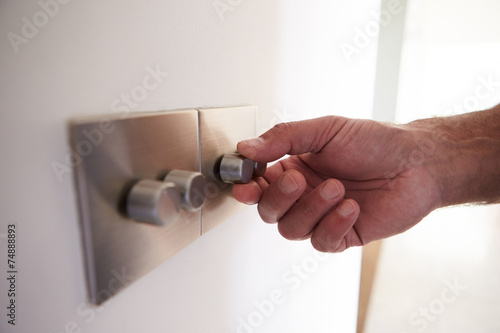 Photos Close Up Shot Of Man Turning Down Electrical Dimmer Switch