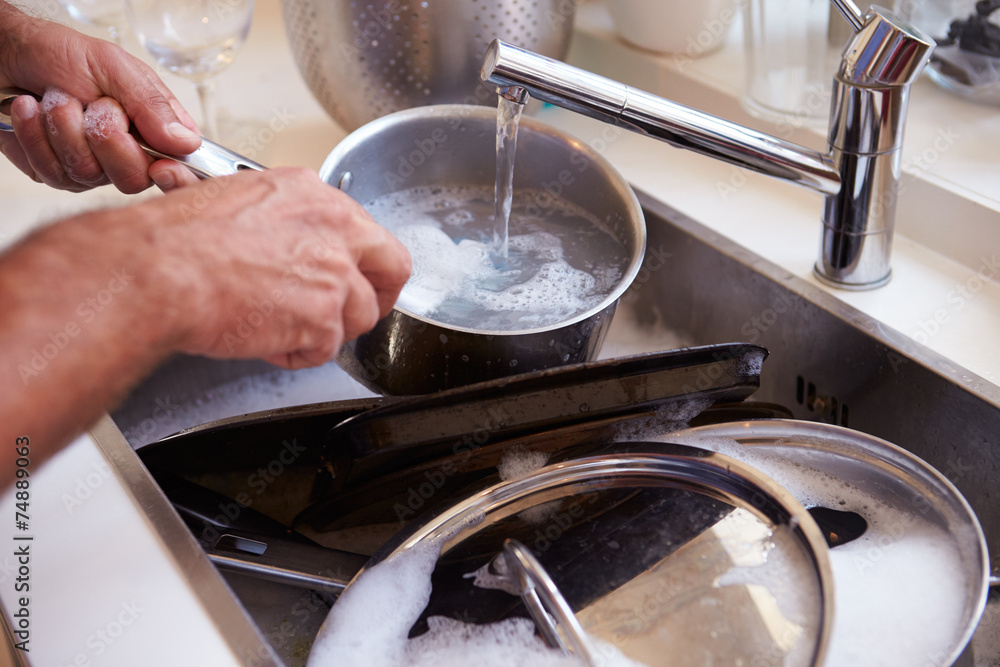 Close Up Of Man Washing Pans In Sink