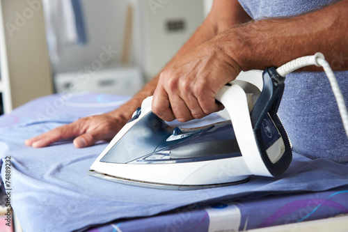 Close Up Of Man Ironing Laundry