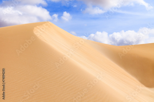 Sand dunes in Boavista desert with blue sky and clouds, Cape Ver