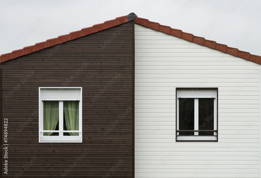 Giebel mit Fassadenplatten und zwei Fenstern mit Rollläden