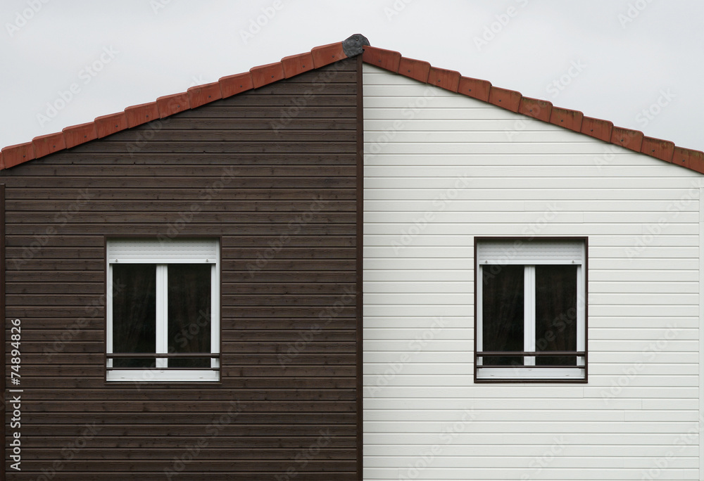 Giebel mit Fassadenplatten und zwei Fenstern mit Rollläden