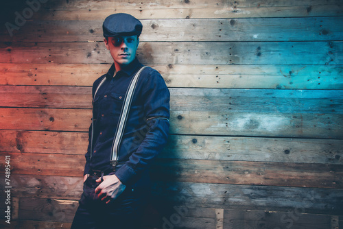 Retro 30s fashion man wearing blue cap, shirt, braces and jeans