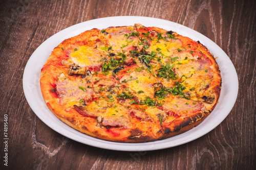 pizza with ham on white plate