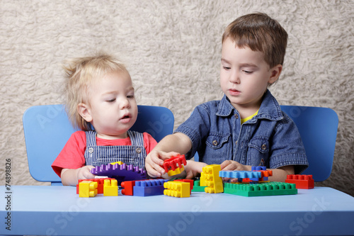 Two cute boy playing blocks table photo