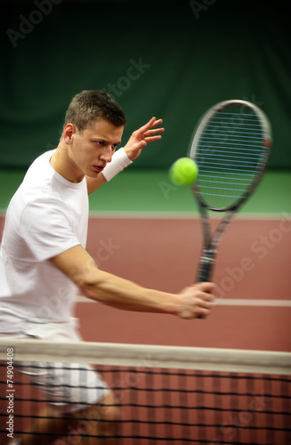 .Young man playing tennis © Mikael Damkier