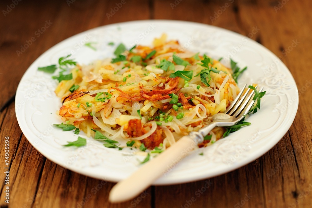 Fried potatoes on white plate with fork Fried potatoes on white plate with fork
