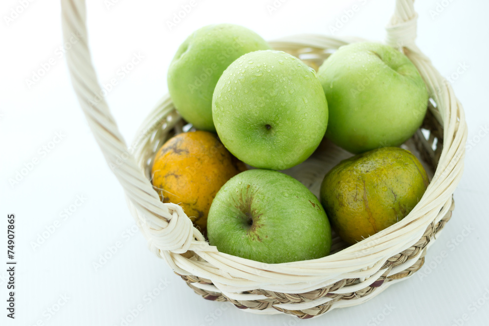 basket of green apples on white background