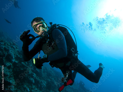 Scuba diver makes OK sign underwater photo