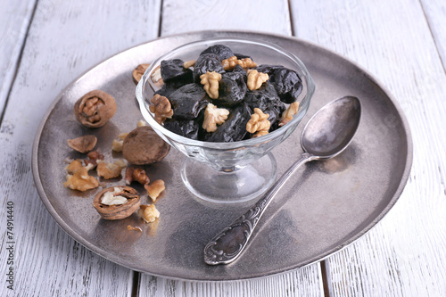 Metal tray with glass bowl of prunes and walnuts, shell and