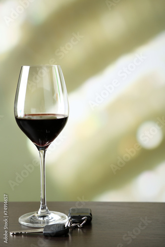 Glass of alcoholic drink and car key,