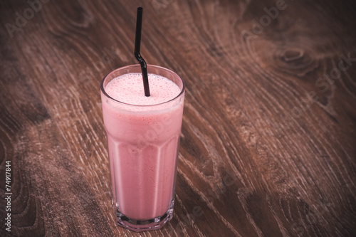 strawberry milkshake with straw in glass