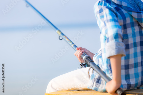 Close-up of hands of a boy with a fishing rod