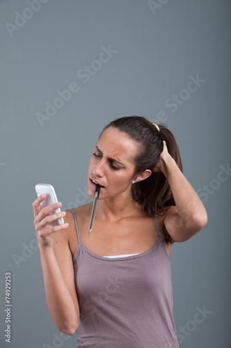 doubtful woman looking mobile phone
