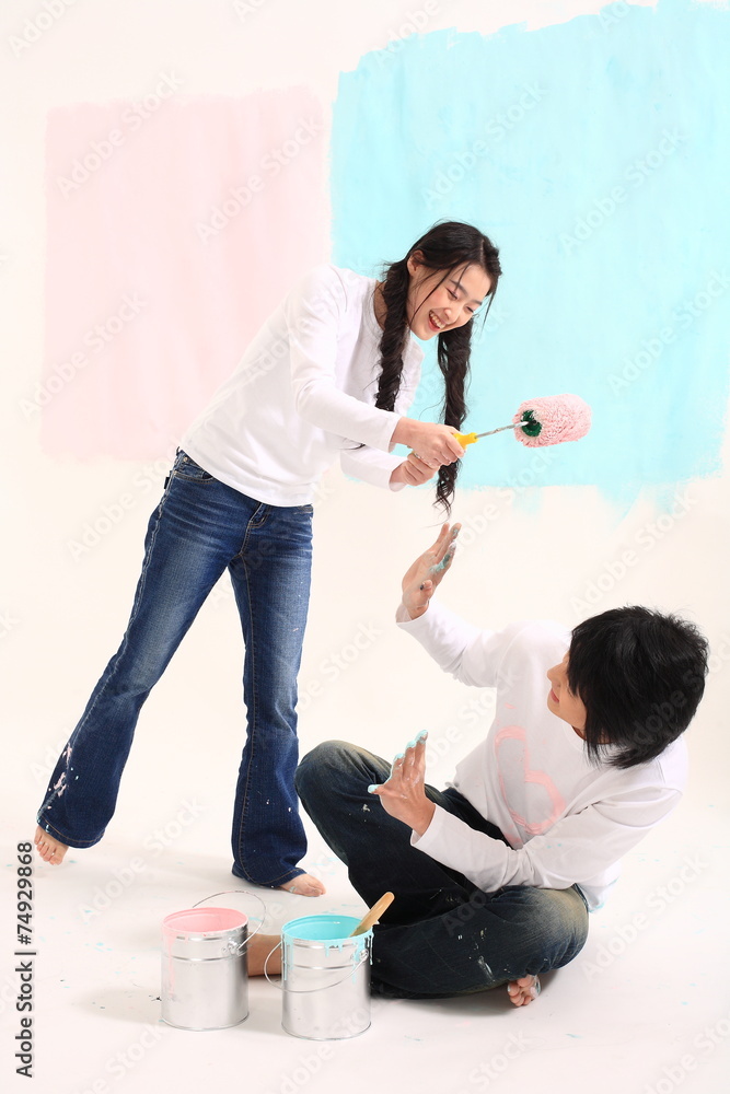 Fototapeta premium 스튜디오 안에서 페인트 칠하는 젊은 커플