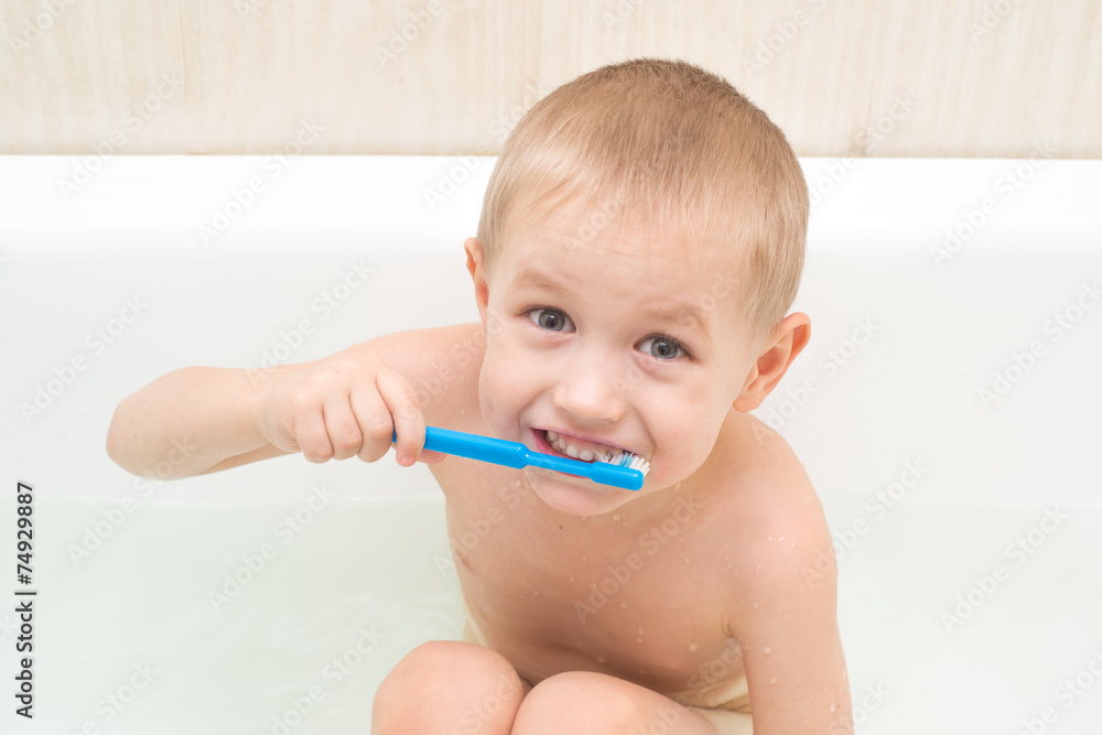 Little boy brushing his teeth blue brush in the bath Little boy brushing his teeth blue brush in the bath