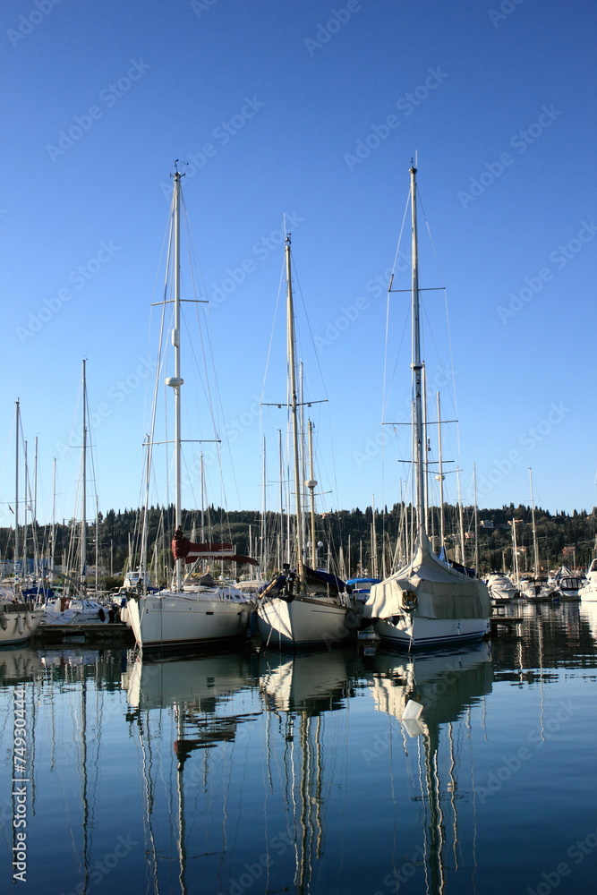 sail Boats and yachts reflected in calm marina