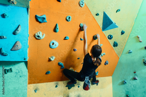 Woman climbing up on wall indoors
