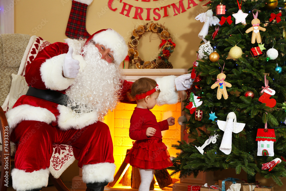 Fototapeta premium Santa Claus giving present to little cute girl near