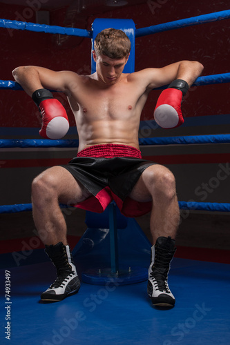 Handsome muscular young man wearing boxing gloves.