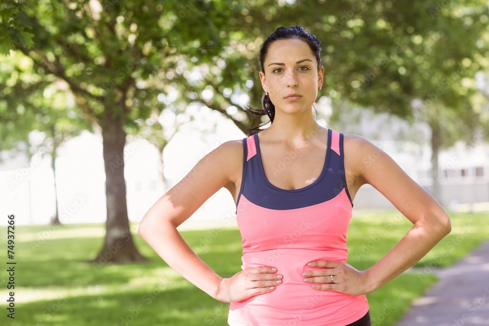Fit brunette thinking with her hands on hips Fit brunette thinking with her hands on hips
