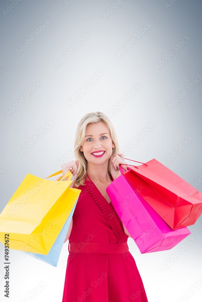 Stylish blonde in red dress holding shopping bags Stylish blonde in red dress holding shopping bags