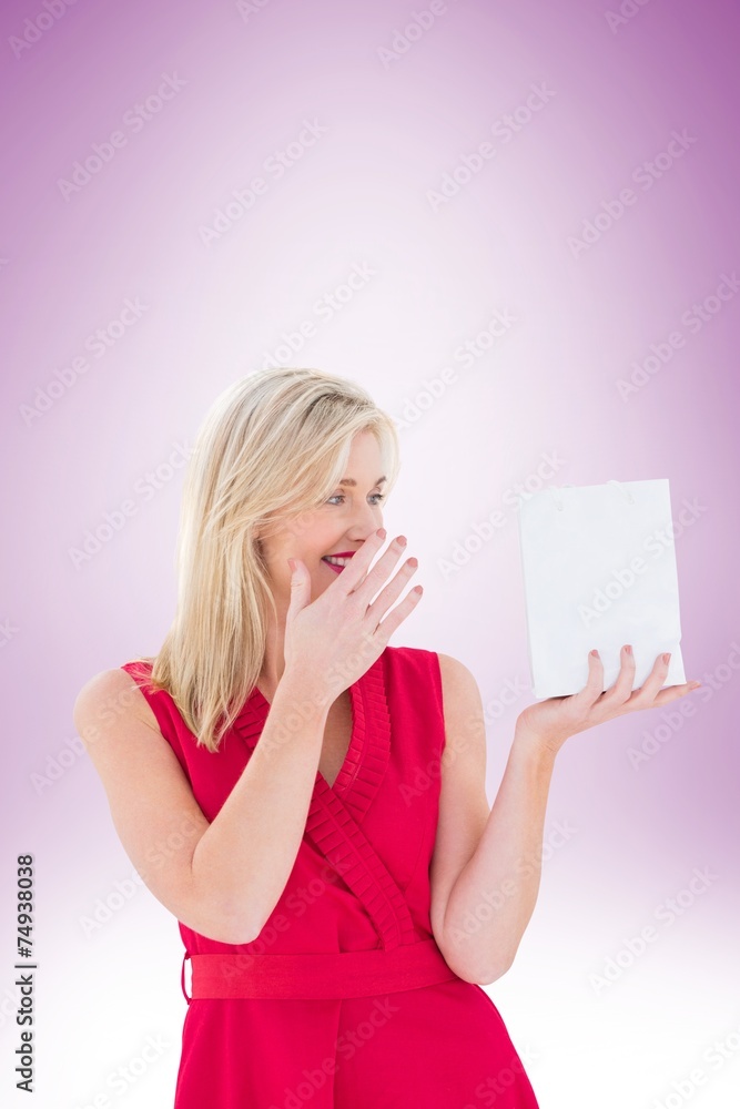 Stylish blonde in red dress holding gift bag Stylish blonde in red dress holding gift bag