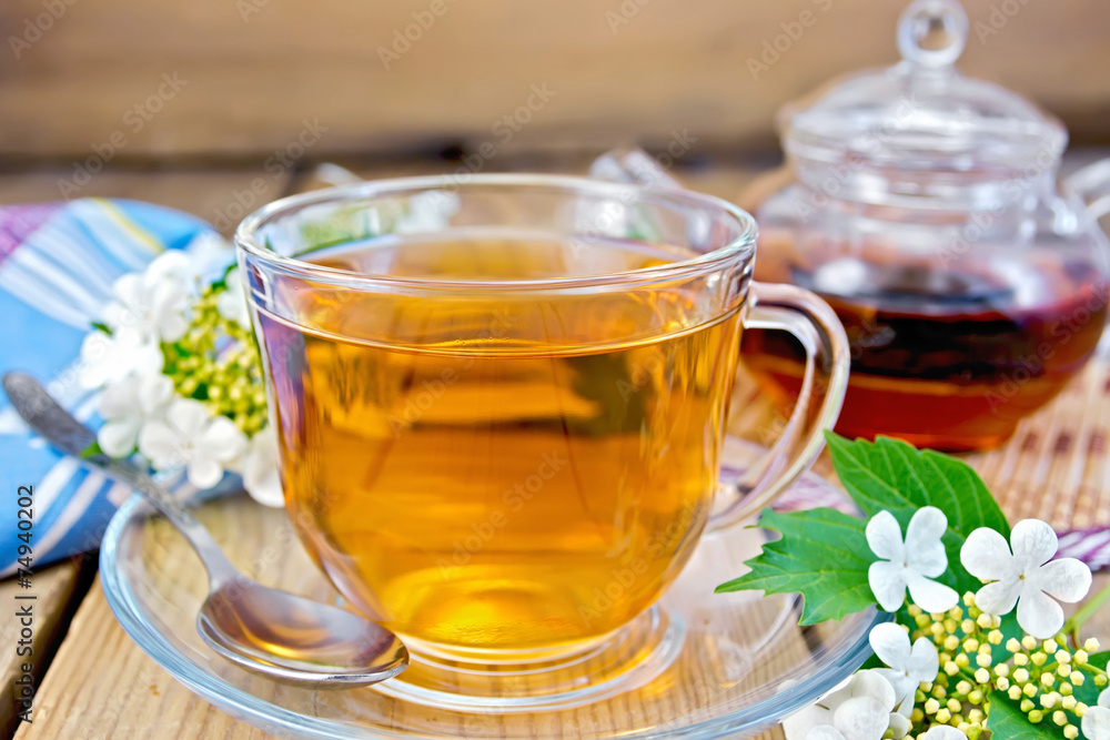 Tea from flowers of viburnum on wooden board with napkin Tea from flowers of viburnum on wooden board with napkin