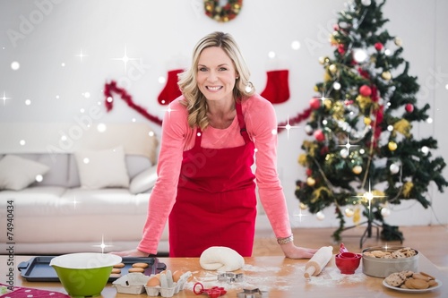 Composite image of festive blonde making christmas cookies