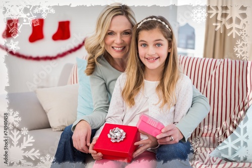 Composite image of daughter opening christmas gift with mother